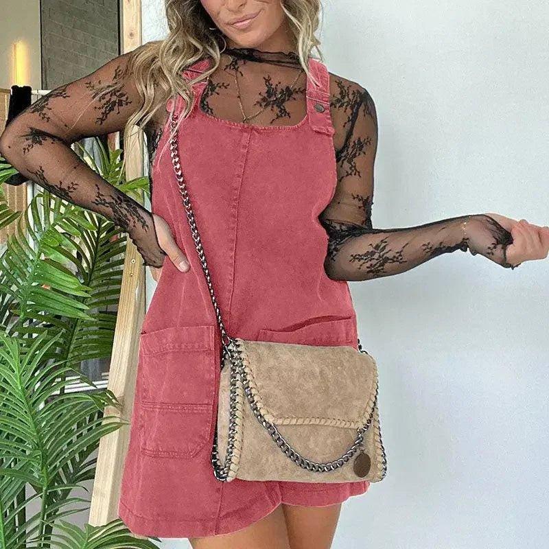 Woman in pink corduroy overall dress with black lace top, carrying chain strap suede bag, fashion outfit