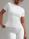 Woman modeling white fitted short sleeve top and matching leggings, stylish women's fashion outfit