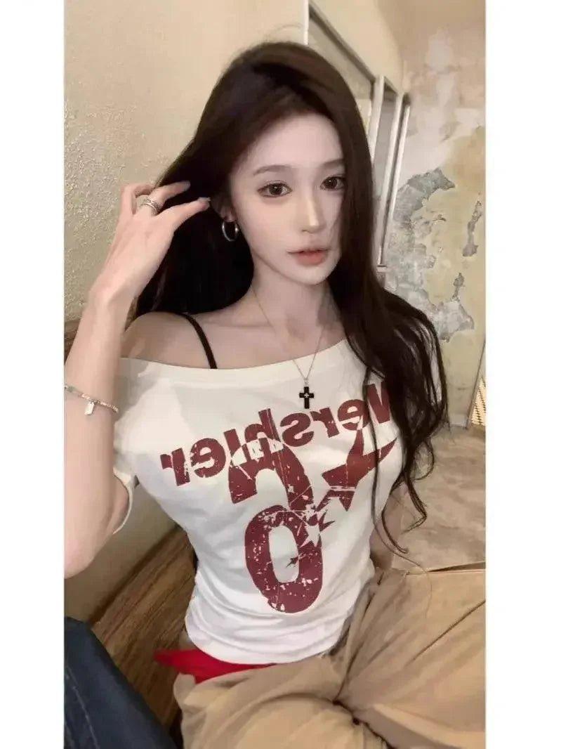Woman wearing white off-shoulder graphic tee with red print, fashion top for casual style