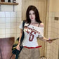 Woman wearing off-shoulder graphic tee with red belt, casual fashion outfit