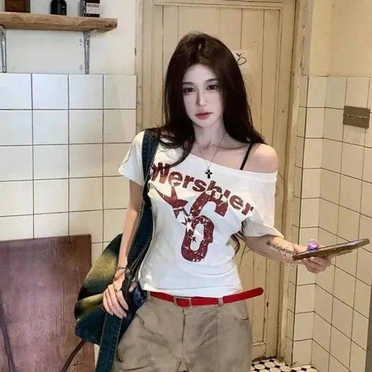Woman wearing off-shoulder graphic tee with red belt, casual fashion outfit