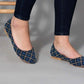Blue patterned flat shoes with white embroidery, worn with dark jeans, stylish women's fashion footwear