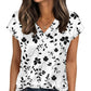 White V-neck floral print women's top with black flowers and leaves, paired with jeans