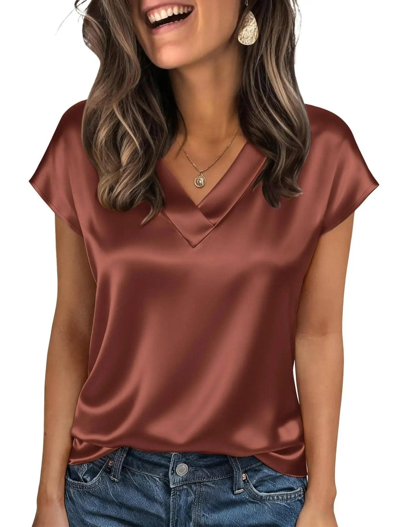 Woman wearing elegant satin V-neck top in rust color, paired with denim jeans, perfect for casual fashion.