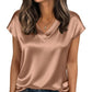 Woman wearing elegant satin V-neck blouse with short sleeves, paired with jeans, perfect for casual fashion.