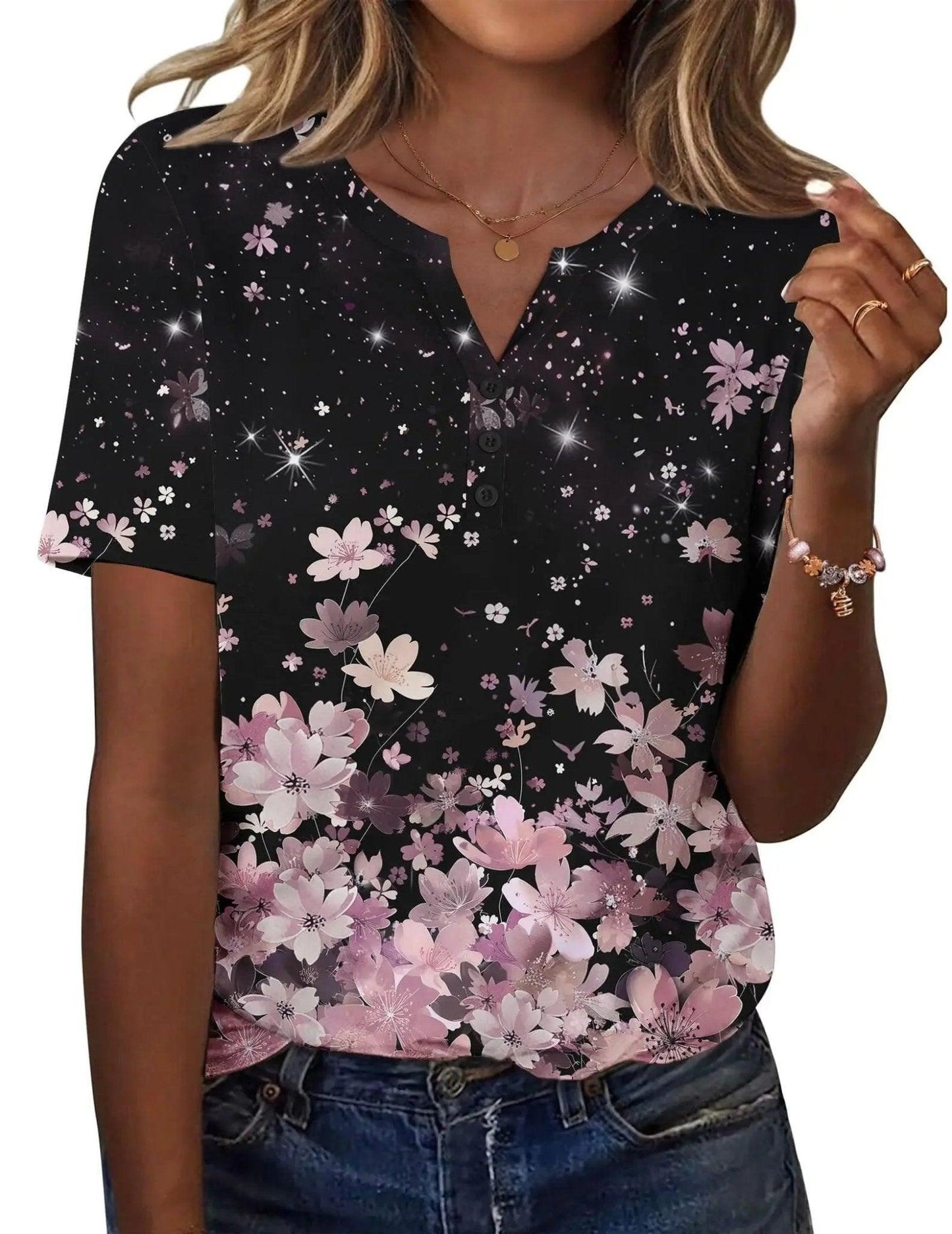Black floral print women's V-neck tee with pink cherry blossoms and sparkle details, paired with jeans