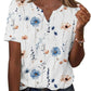 Women's floral print V-neck blouse with blue and peach flowers, short sleeves, button front, paired with jeans