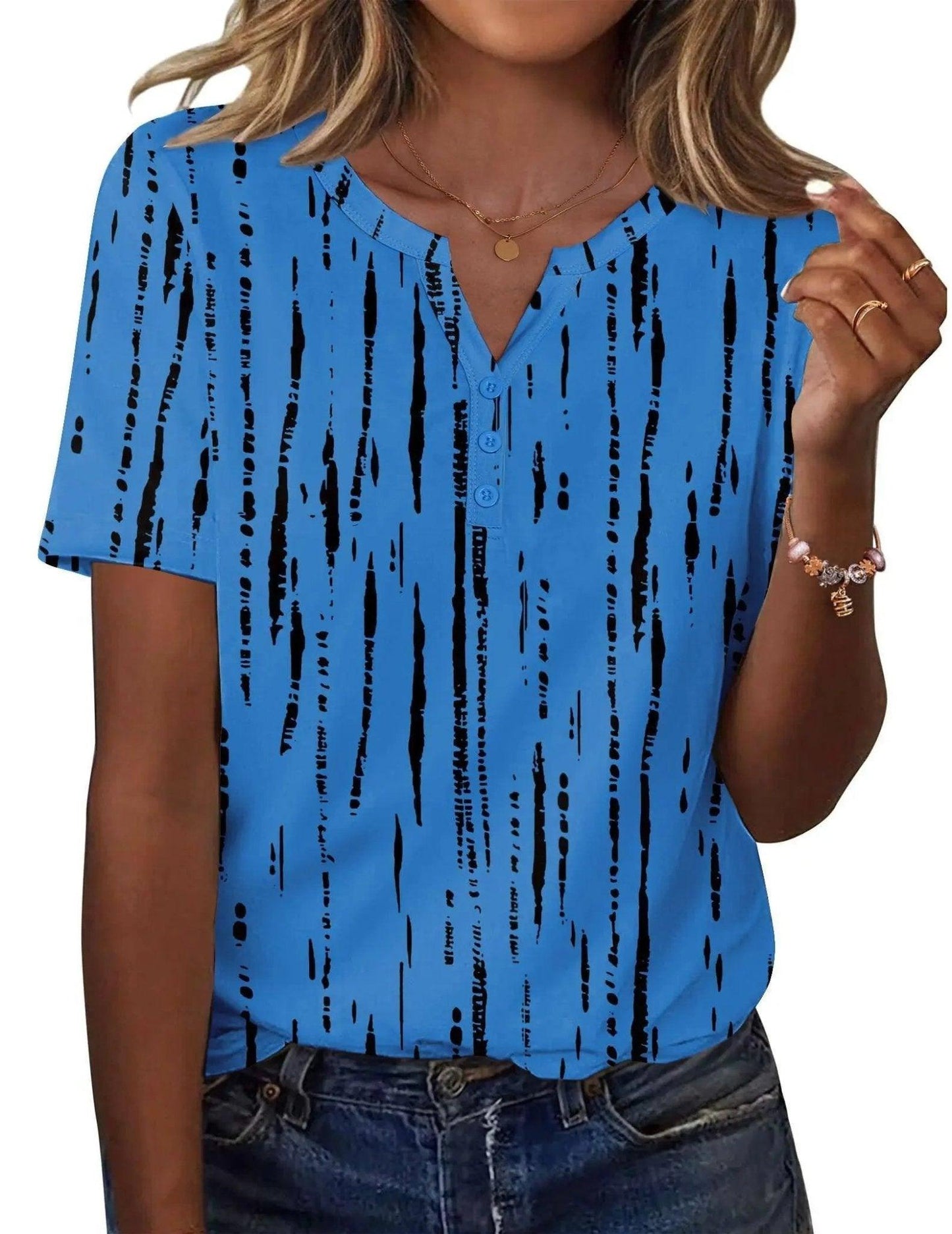 Blue women's V-neck short sleeve top with black abstract print, paired with jeans for casual fashion.