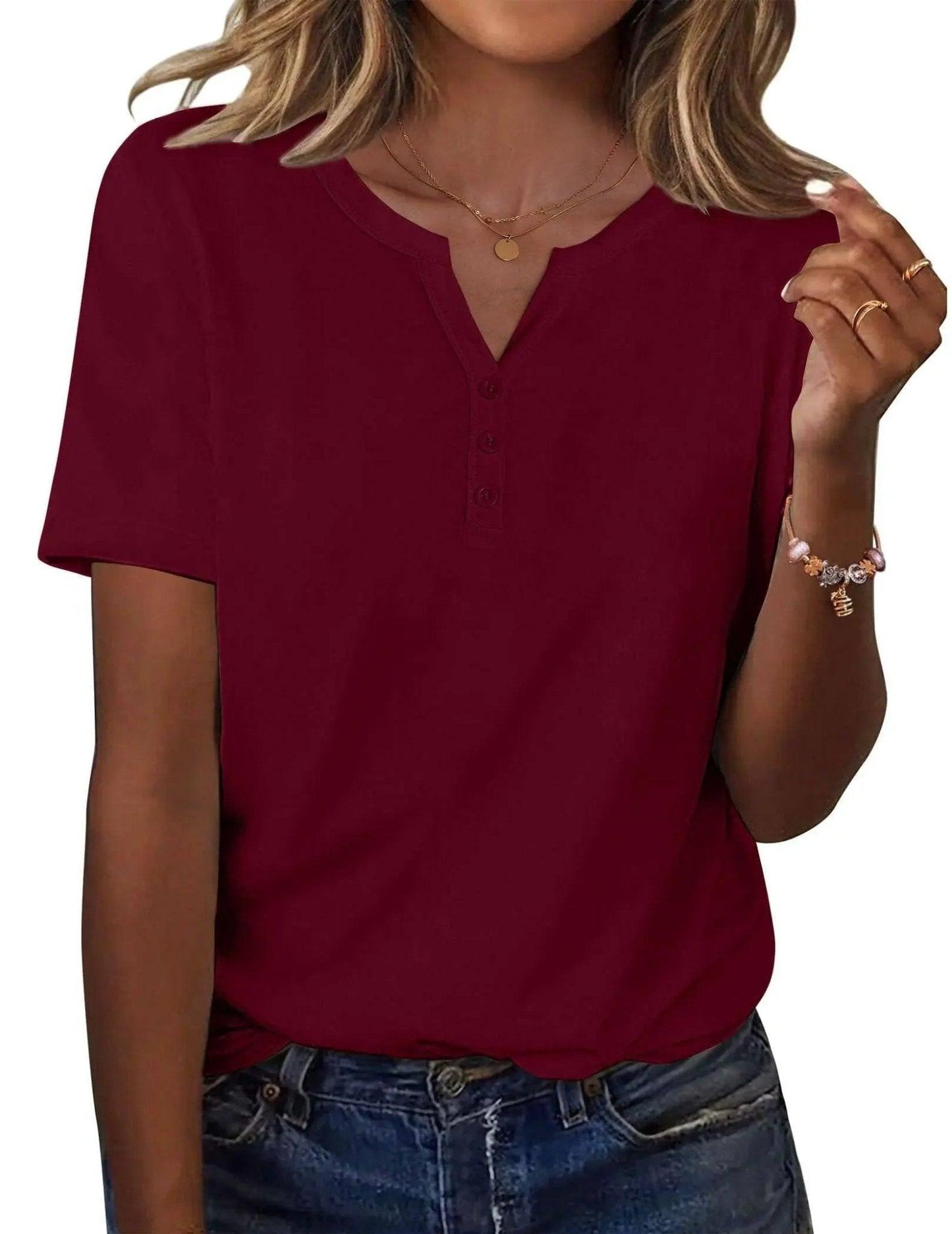 Burgundy women's V-neck button-up t-shirt with short sleeves, paired with denim jeans and gold jewelry