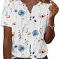 Women's floral print V-neck blouse with blue and peach flowers, short sleeves, button front, paired with jeans
