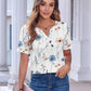 Floral print women's V-neck blouse with short sleeves, paired with jeans and clutch, perfect for casual fashion.