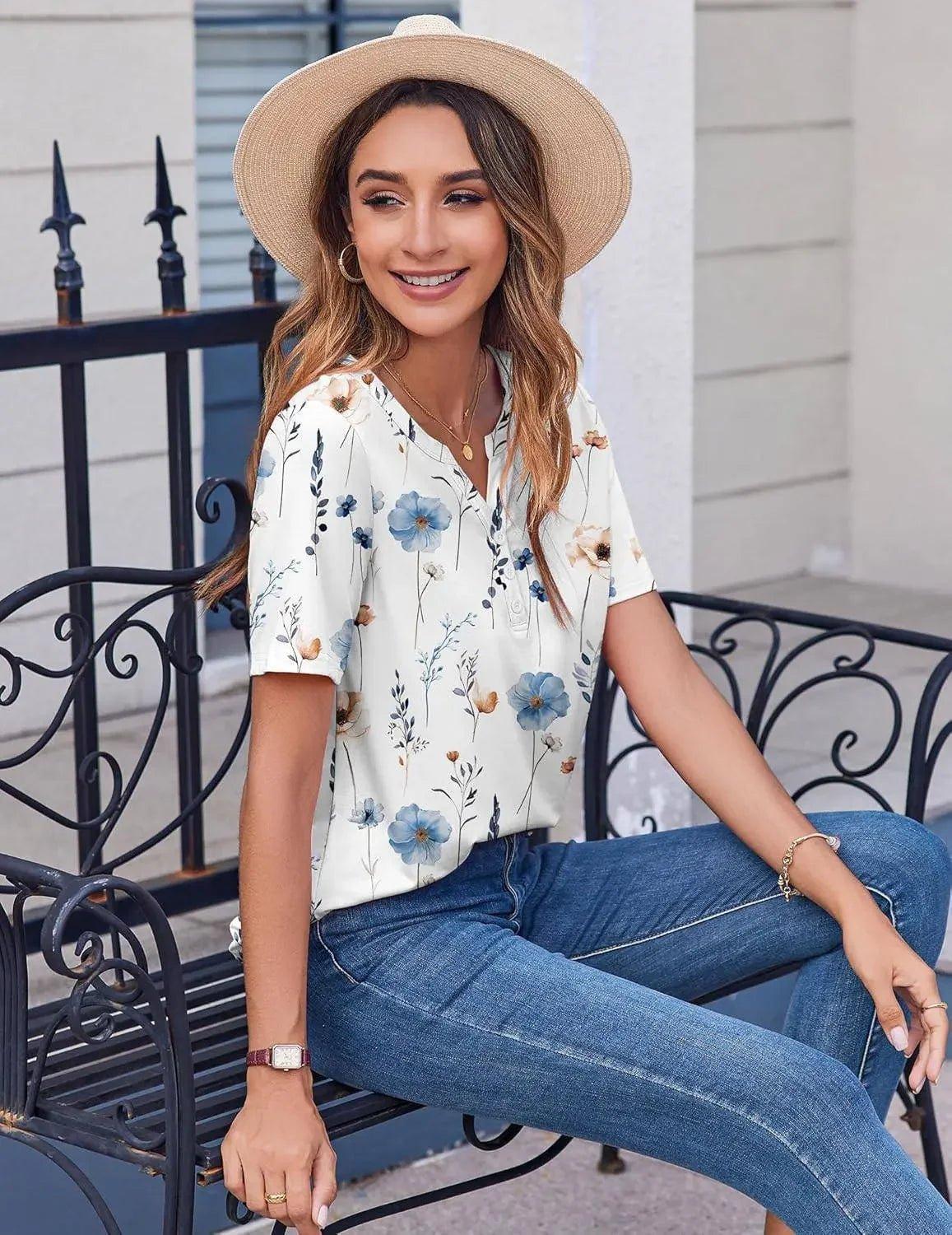 Woman in floral print blouse, straw hat, and jeans sitting on bench