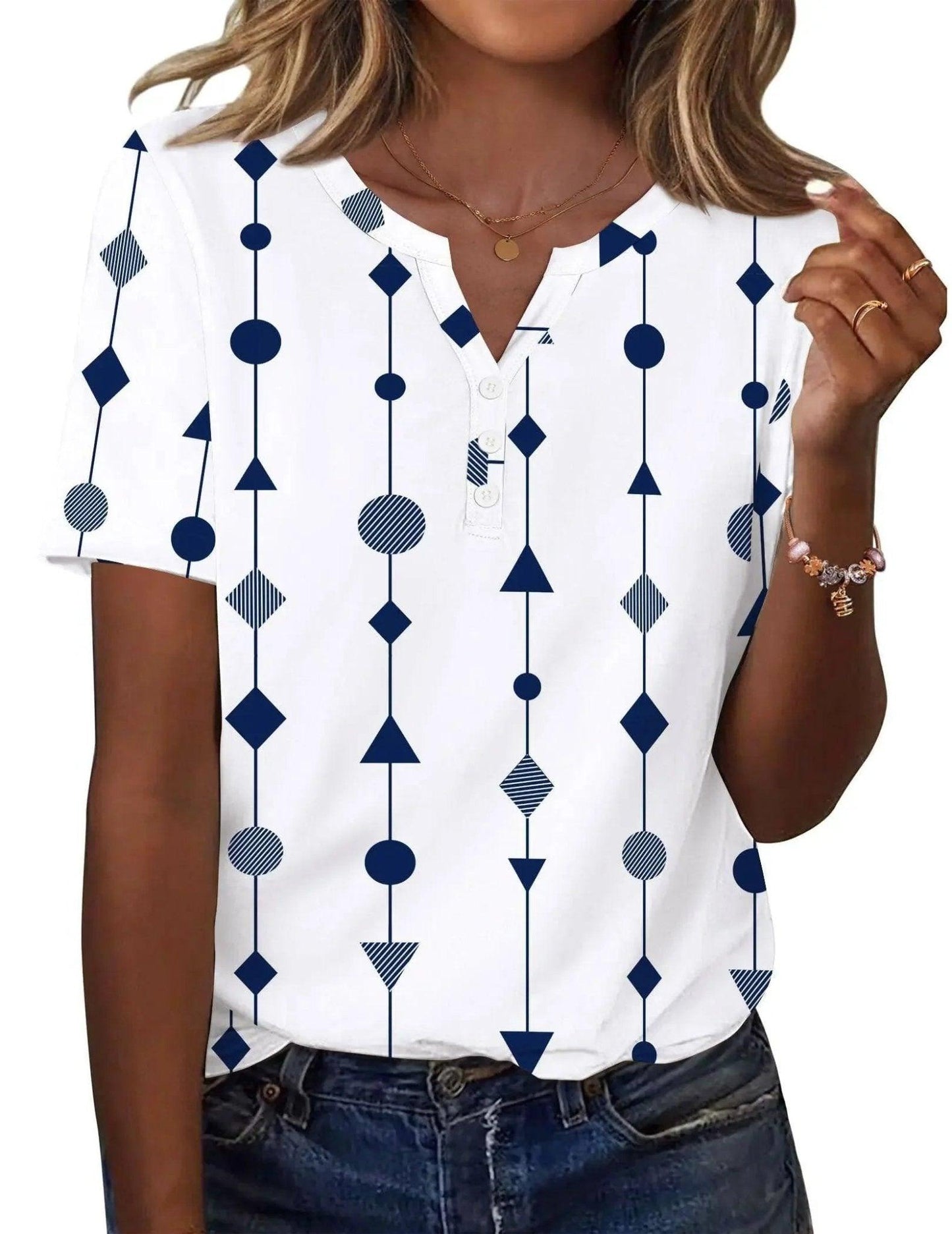 White women's geometric print V-neck top with navy blue shapes, short sleeves, and button detail