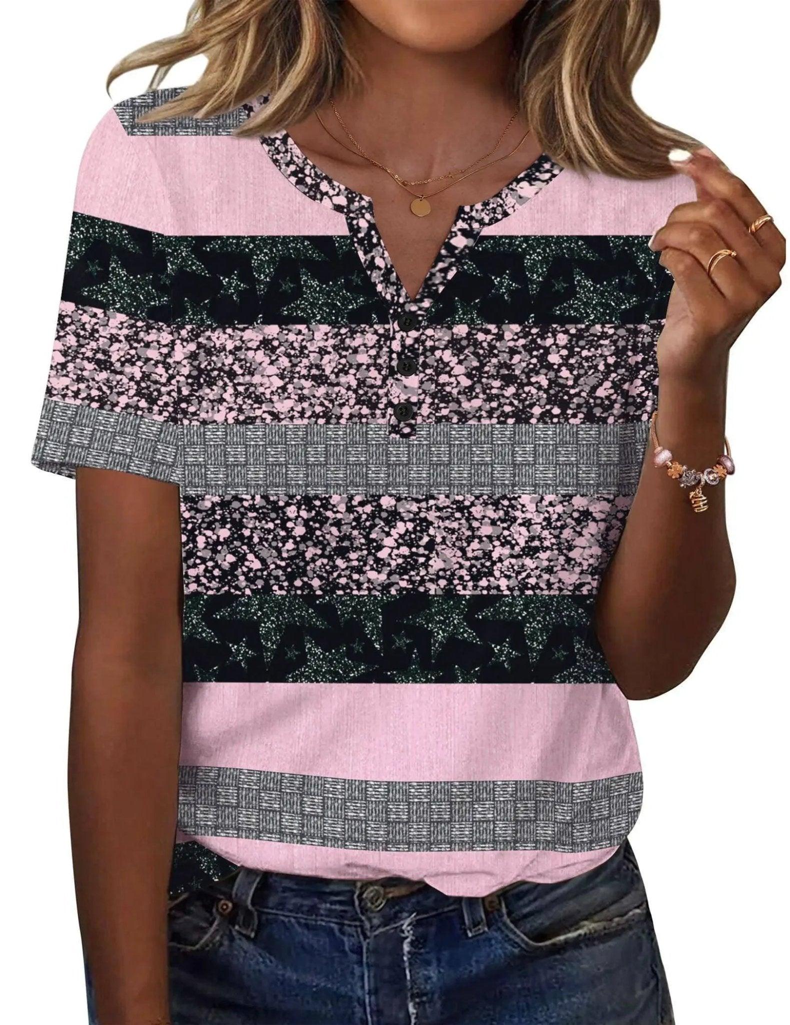 Women's pink and black patterned short sleeve top with button front and V-neck, paired with jeans.