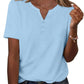 Light blue women's V-neck button-up t-shirt with short sleeves, paired with denim jeans and layered necklaces
