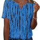 Blue women's V-neck button-up top with black abstract print, paired with denim jeans for casual fashion.